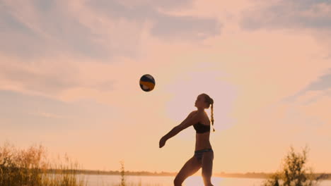 Gruppe-Junger-Mädchen,-Die-Beachvolleyball-Bei-Sonnenuntergang-Oder-Sonnenaufgang-In-Zeitlupe-Spielen.-Schöne-Mädchen-Im-Bikini-Spielen-Professionell-Volleyball-Auf-Dem-Sand