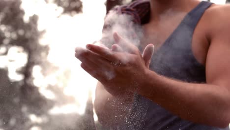 man chalking his hands for rock climbing