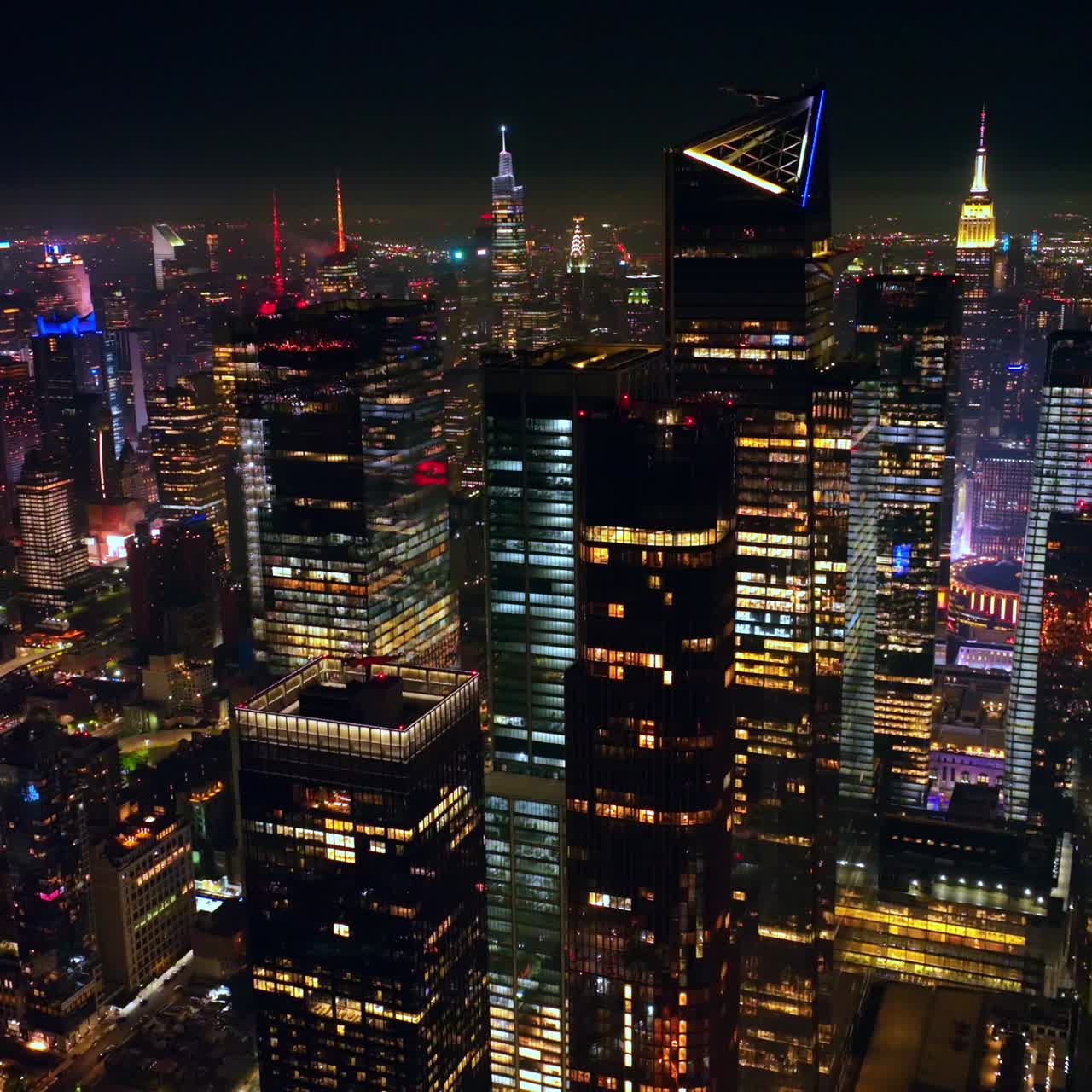 Colorful diverse lights of nighttime New York. Crazy traffic flow around the streets of metropolis at night. View from above