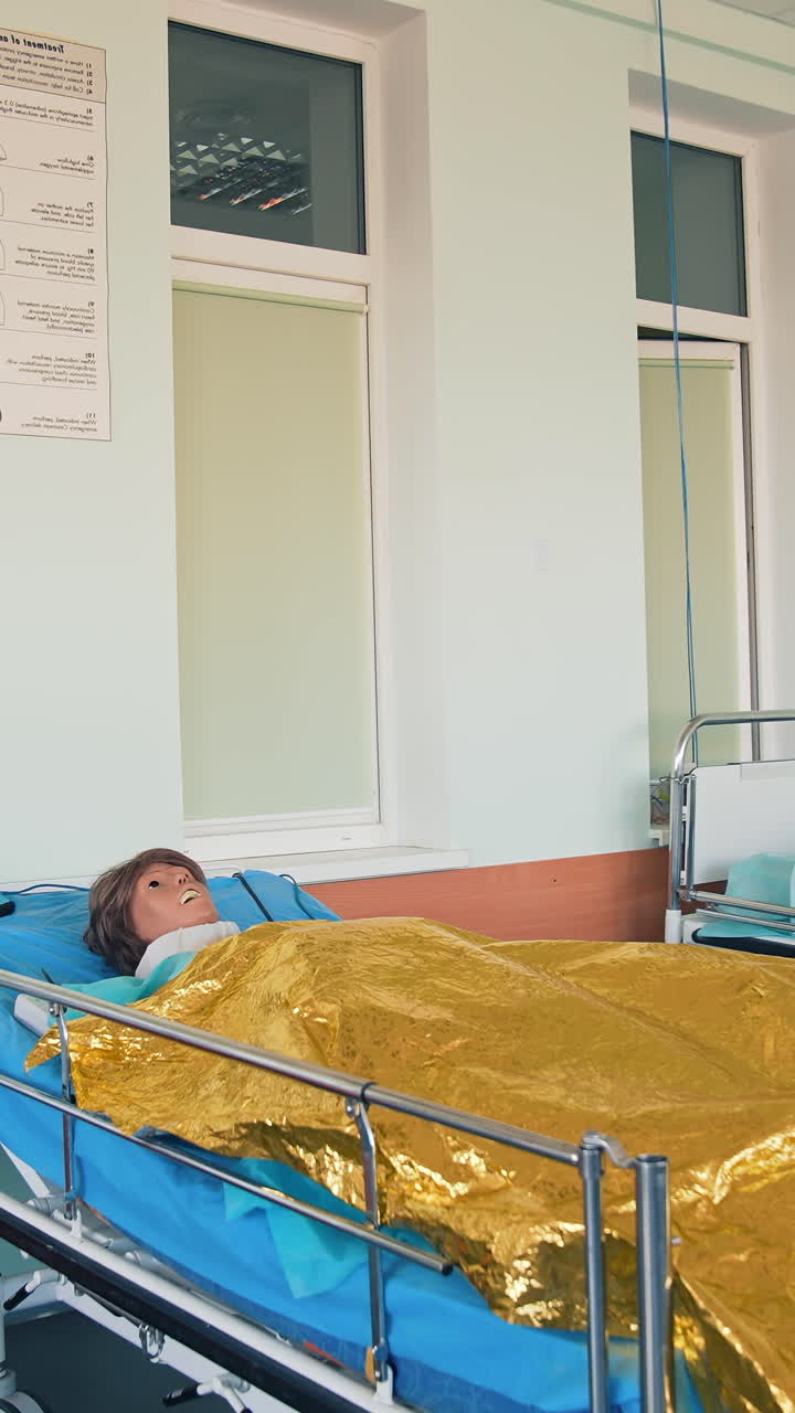 Medical mannequin on bed. Practicing with medical simulation mannequin in hospital. Vertical video