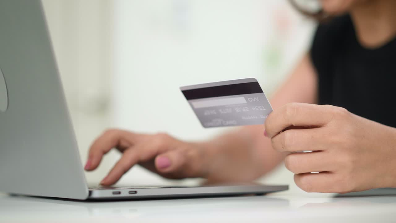 mujer con tarjeta de crédito y portátil