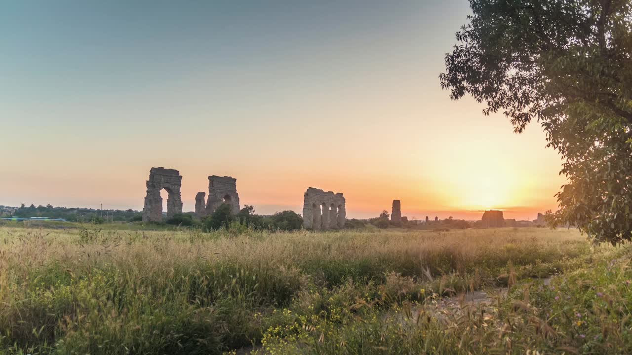 A timelapse of the sunset in Roma, Italy. Nice nature shot, with old Aqueducts ruins, Trains, trees, and a sunset.