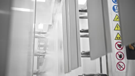 automated white spray painting of parts on a factory