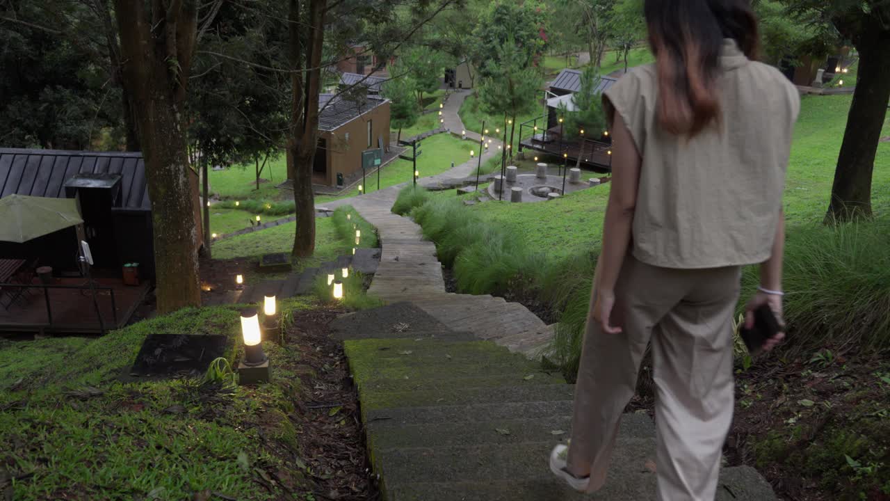 A girl walks down a stone staircase in a peaceful natural park setting