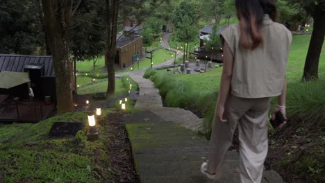 A girl walks down a stone staircase in a peaceful natural park setting