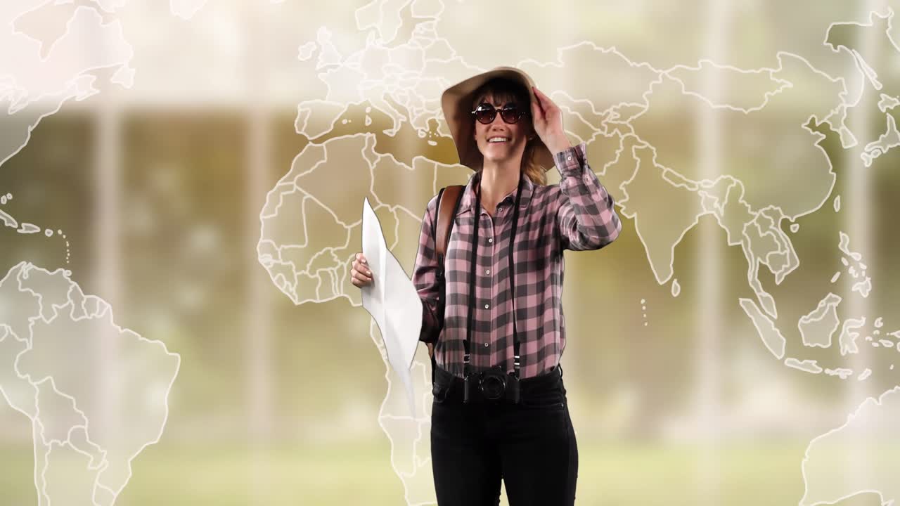 Animation of happy caucasian woman in hat with map over world map