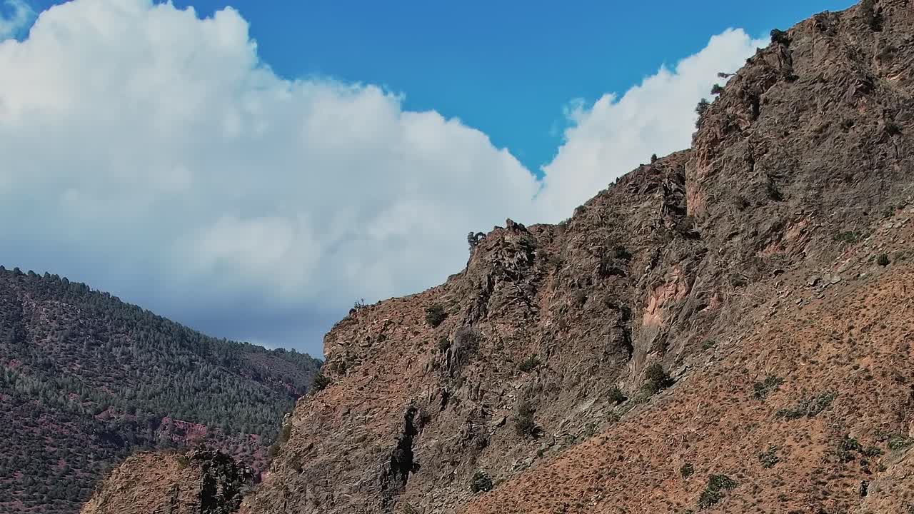 Scogliere verticali si ergono alte sul paesaggio in Marocco con nuvole sopra
