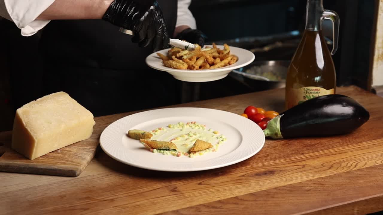 Chef Plating Fried Vegetables with Sauce in a Professional Kitchen