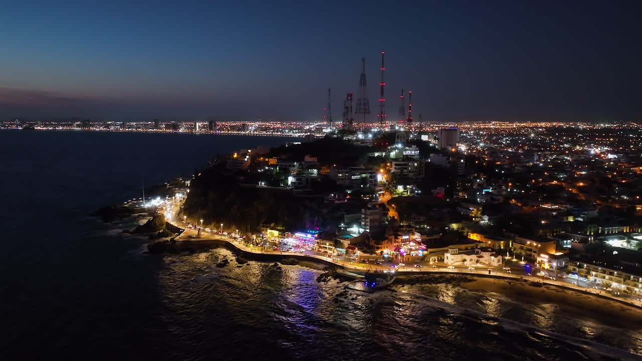 vista aérea lejos de la colina de la caja de hielo y la costa iluminada por la noche de mazatlan, méxico