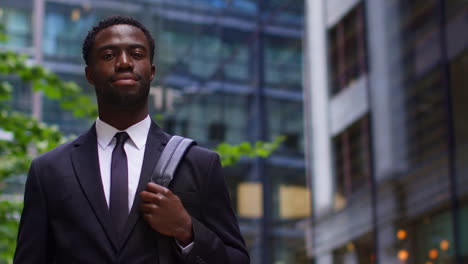 Portrait-Of-Confident-Young-Businessman-Wearing-Suit-Standing-Outside-Offices-In-The-Financial-District-Of-The-City-Of-London-UK-3