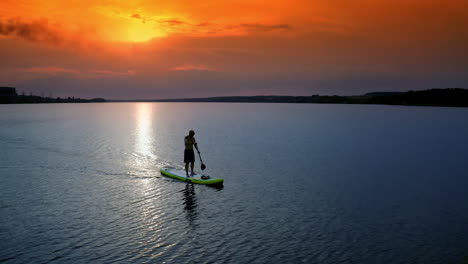 athletic man standing with paddle. surfer floating sup board on vacation