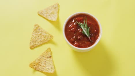 Video-Von-Tortillachips-Und-Salsa-Dip-Auf-Einer-Gelben-Oberfläche