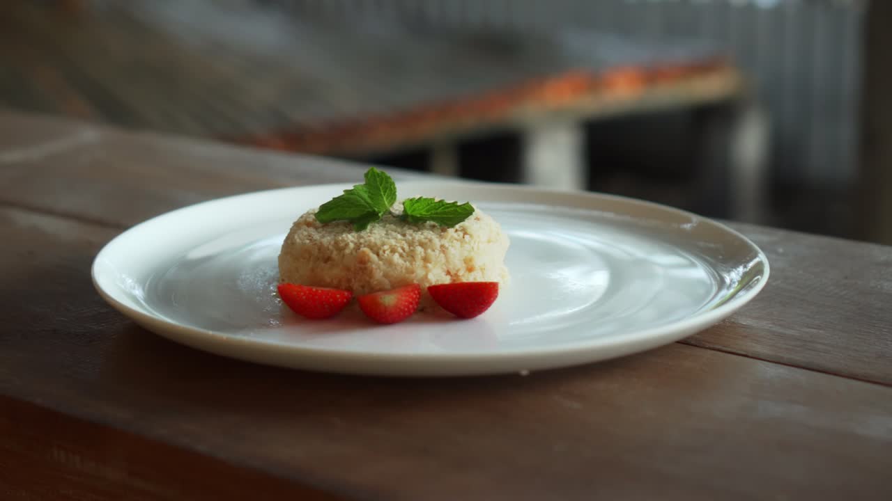 Piccola torta millefoglie con fragole sopra, su un piatto bianco