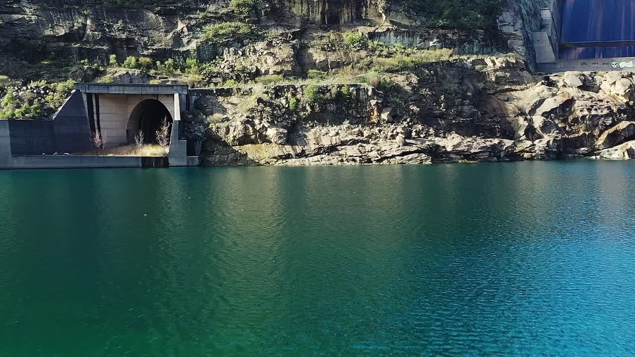 Il Lago Colbún in Cile con acqua limpida e dintorni rocciosi