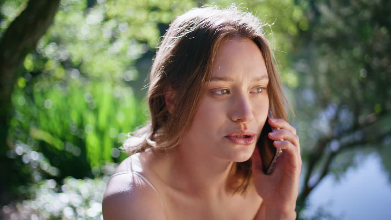 Closeup woman calling mobile phone sitting green nature. Happy lady