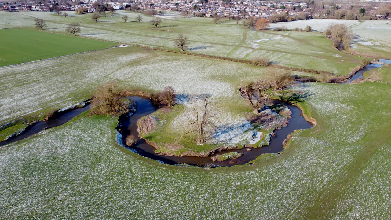 вид с воздуха извилистой реки стрела, протекающей через поля в уорикшире, англия, солнечным морозным зимним утром