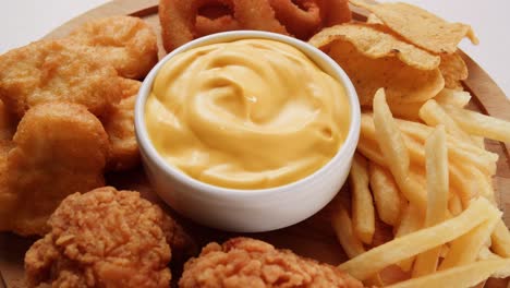 variedad de alimentos fritos con salsa de queso
