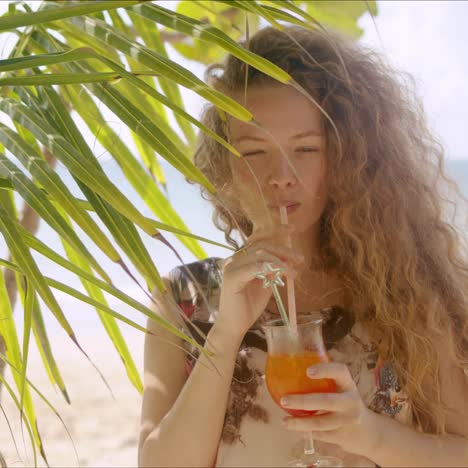 Attractive-female-drinking-beverage-beside-palm-tree