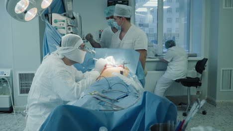 doctor with assistants operates patient in room. cardio surgeon with team conducts modern artery bypass surgery in clinic. heart disease therapy