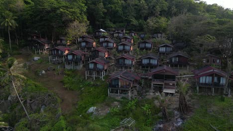 aerial view of traditional housing complex in long beach , a tropical malaysian island, showcasing lush greenery. rocky coastline. and crystal clear turquoise waters
