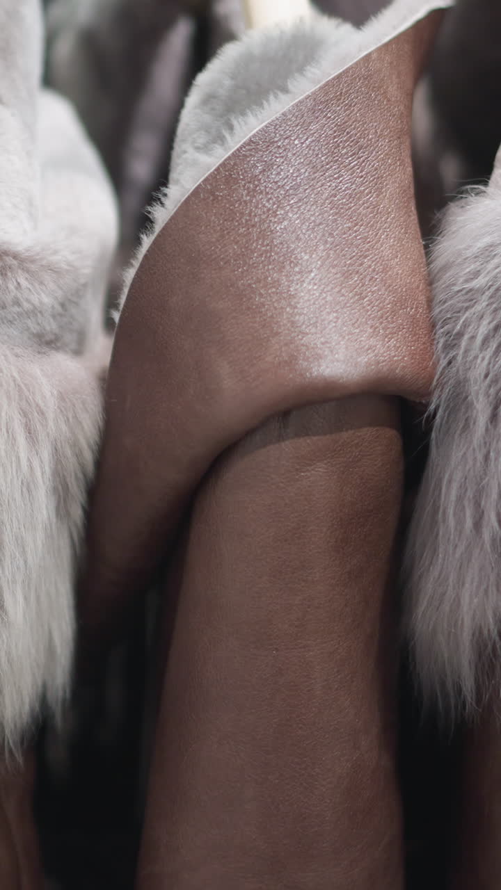 Close-up of luxurious brown jackets with soft, plush fur collars, showcasing detailed textures and elegant craftsmanship in modern outerwear in a well lit store