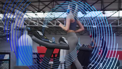 Animation-of-blue-spiral-rotating-over-women-in-face-masks-exercising-on-running-machines