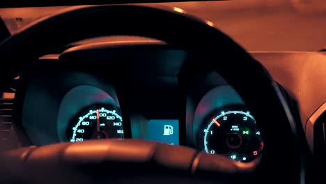 steering wheel and speedometer in a car while driving at night