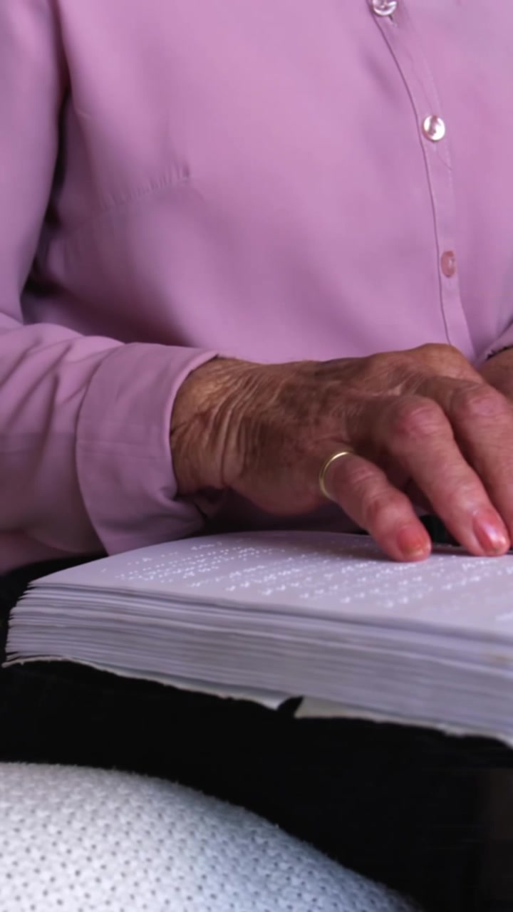 Animazione di lettere su un'anziana donna caucasica che legge il Braille