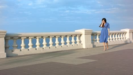 beautiful young woman walking and talking with cell phone