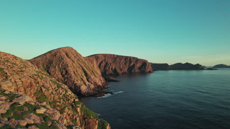 Drone-follwing-Coastline-in-a-Beautiful-Sunset-Atmosphere-in-Northern-Norway,-Norwegian-Cliff-Landscape,-North-Cape,-Scandinavia