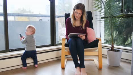 Mutter-Nutzt-Digitales-Tablet,-Während-Sie-Sich-Um-Ihr-Baby-Kümmert,-4K