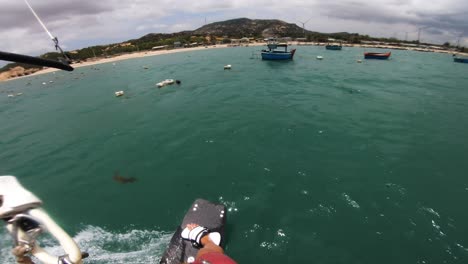 pov of a kiteboarder enjoying kiteboarding on sea with garbage floating on water at son hai, vietnam.
