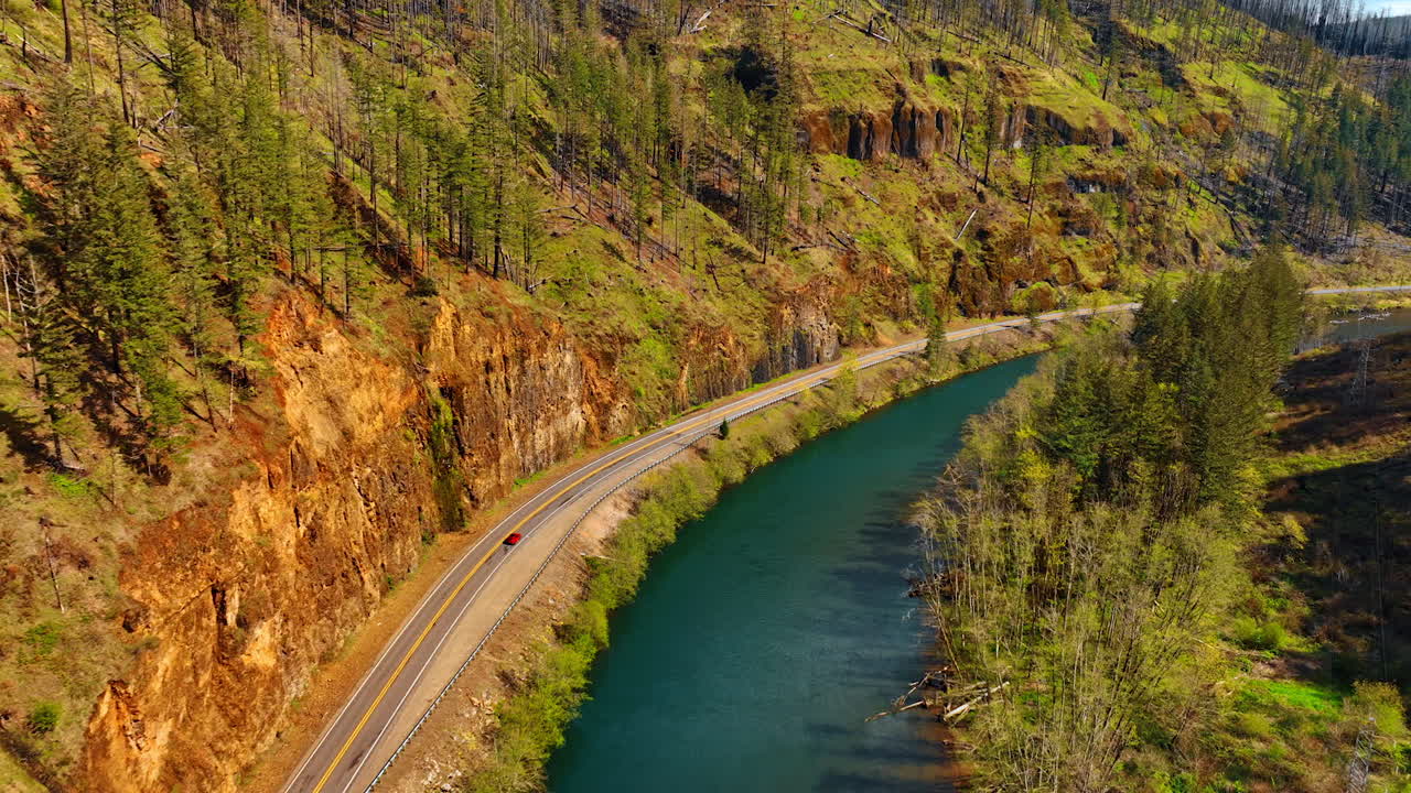 Bare rocks and narrow river at the foot. Sunny view of the mountains in Oregon State, the USA.