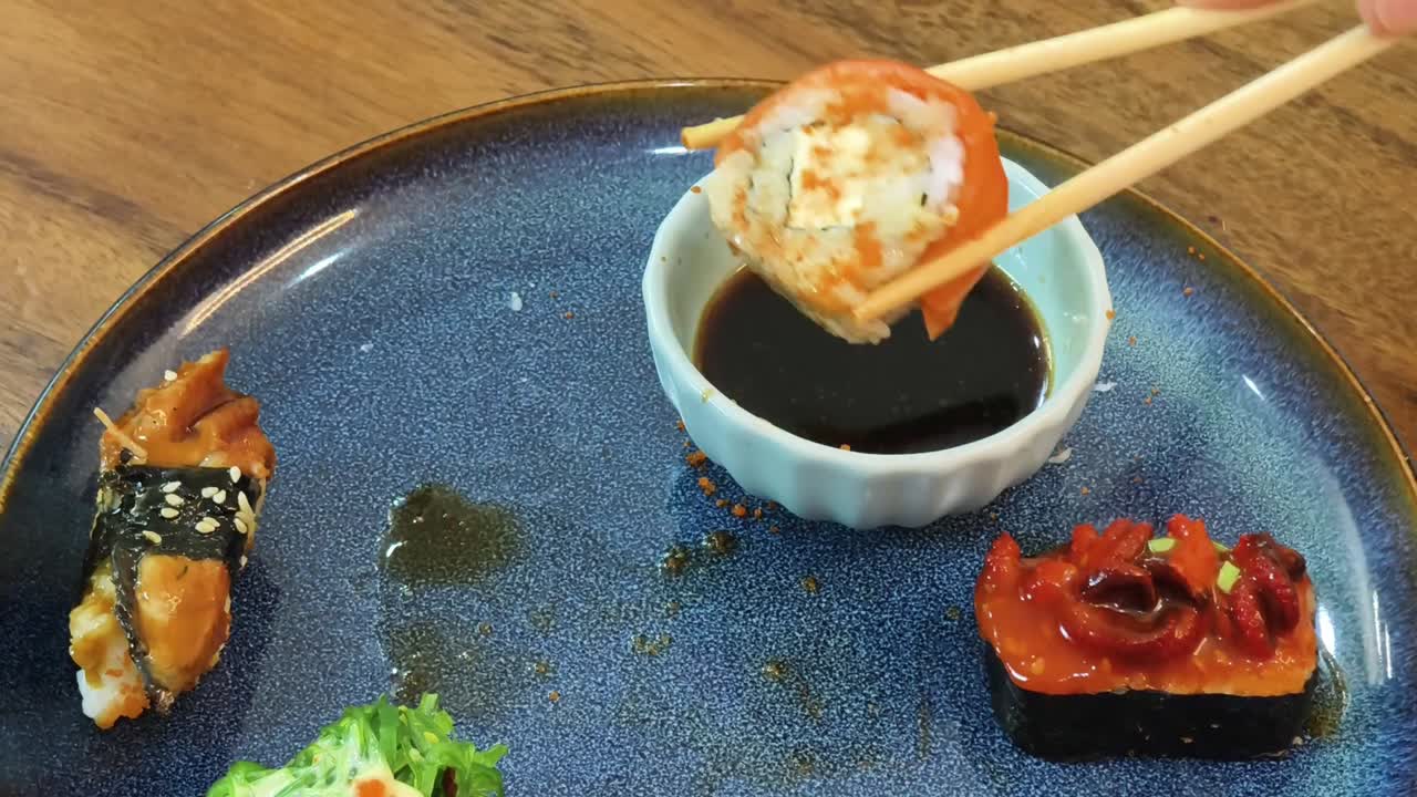 サーモンロールと箸が乗った寿司皿