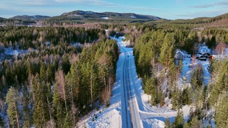 un paisaje nevado con una carretera en skorped, suecia, rodeado de bosque de coníferas, vista aérea