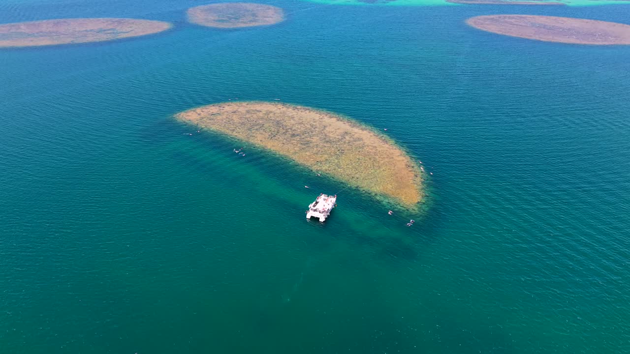 Tour boat anchored for snorkeling among shallow coral reefs in Kaneohe Bay