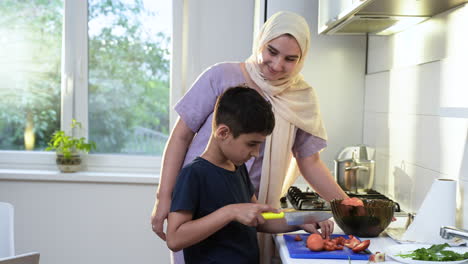 side view of mother with hiyab and her son in the kitchen.