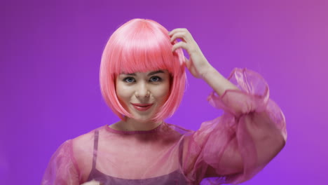 portrait shot of a beautiful woman wearing a pink wig posing and smiling