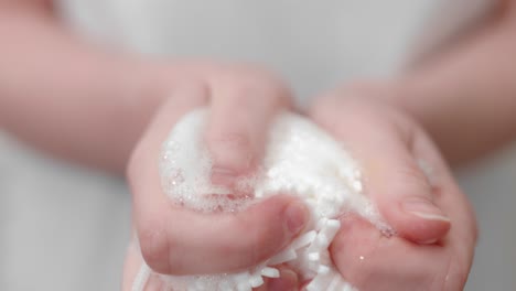 woman holds white body puff full with soap, body care concept