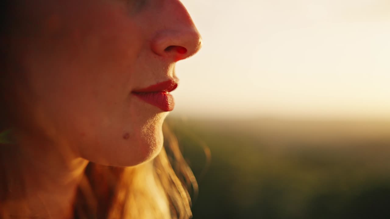 Slow motion close-up shot of a models face and lips with bright red lipstick