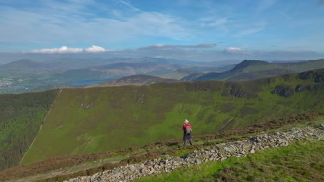 Mountain-trekker-stopped-on-path-admiring-distant-misty-mountains-and-valleys