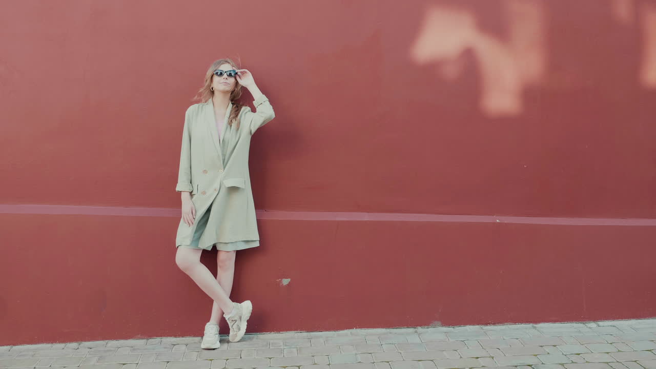 mujer elegante con abrigo beige y zapatillas de deporte