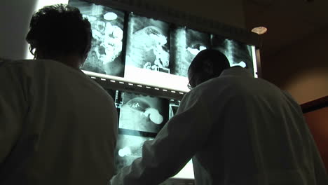 medical professionals evaluate xrays on a wall light box