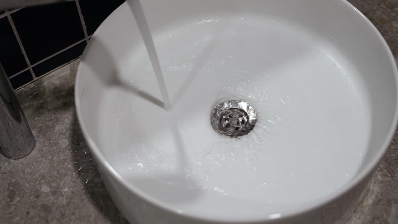 Water flowing into a modern white sink