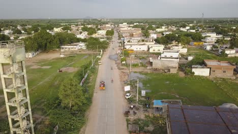 Drohnen-Luftaufnahmen-Eines-Traktors,-Der-Durch-Die-Straßen-Einer-Stadt-In-Indien,-Asien-Fährt