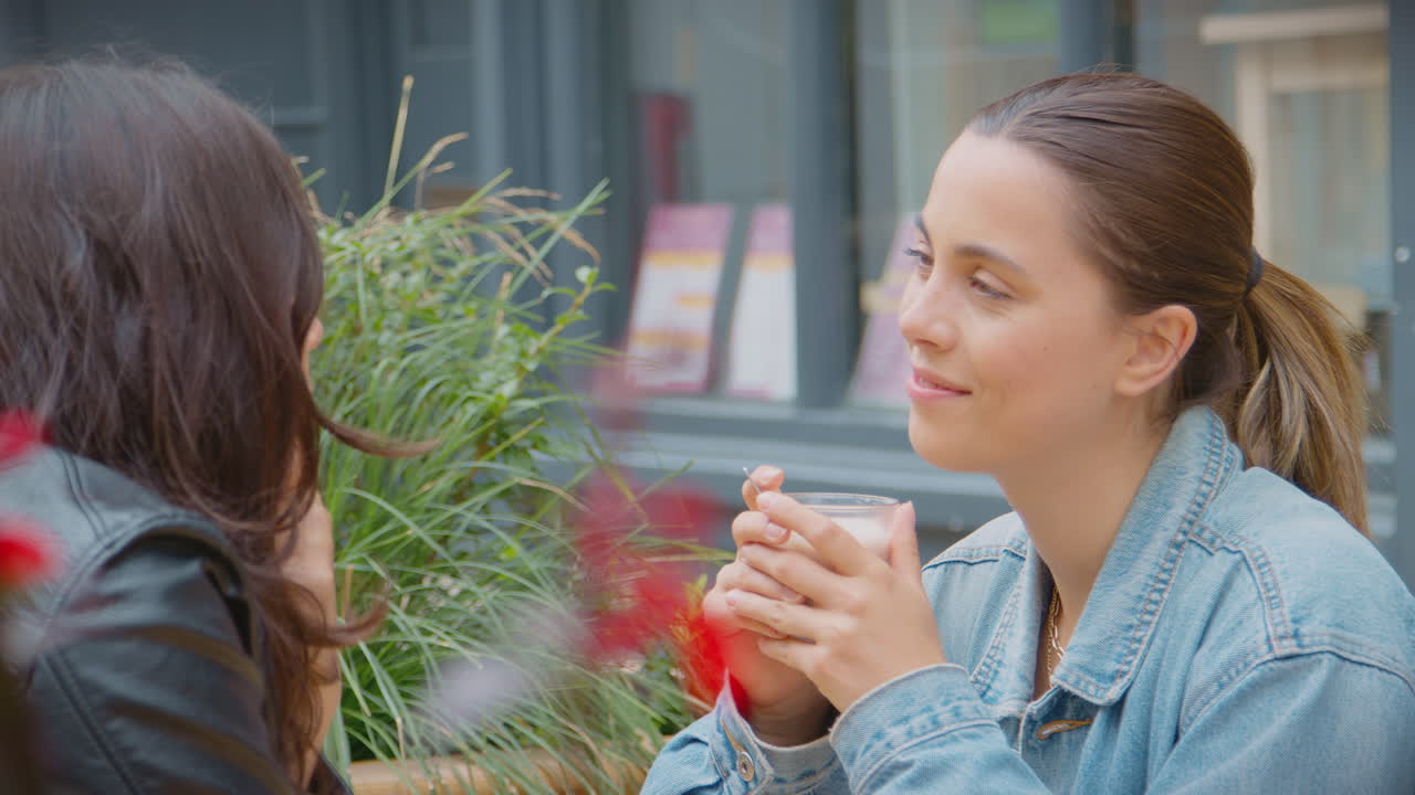 동성 여성 커플이 함께 커피 ⁇ 에서 바 ⁇ 에서 만나고 앉아 있습니다.