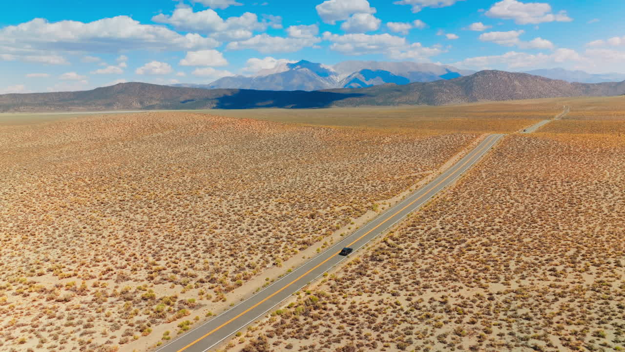 Road trip from California to Nevada through the lifeless desert. Amazing blue skies with white clouds at backdrop.