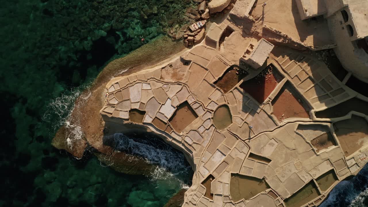 воздушный снимок человека, идущего по соляным бассейнам в ксвежни во время красивого заката.