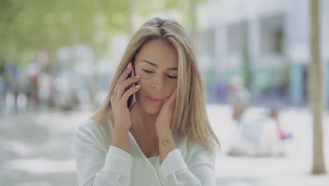 Verärgerte-Junge-Frau,-Die-Draußen-Mit-Dem-Smartphone-Spricht