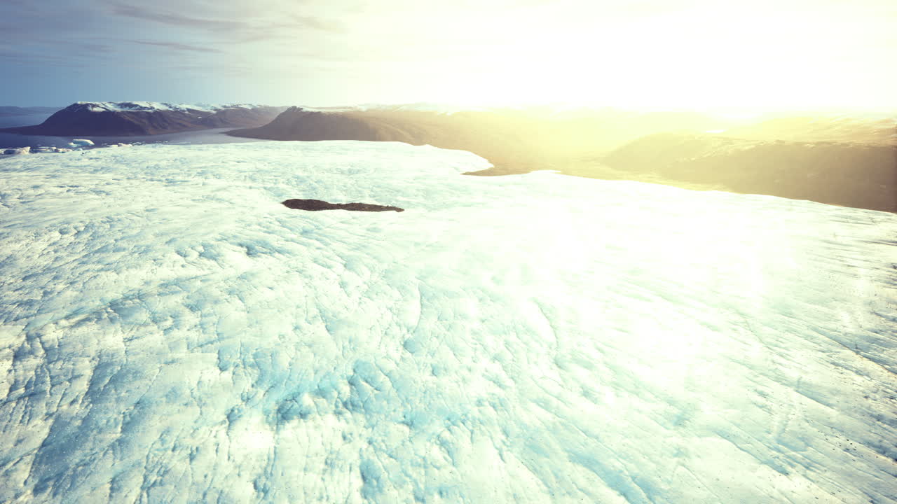 Expansive glacier landscape illuminated by soft sunlight at sunrise